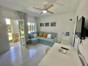 a living room with a couch and a table at Forcat - Apartamento con jardín y piscina in Ciutadella
