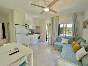 a living room with a blue couch and a kitchen at Forcat - Apartamento con jardín y piscina in Ciutadella