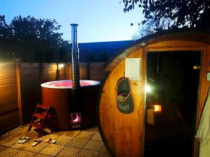 a small sauna with a hot tub in a wooden building at Pod orehom drvena kuća i sauna in Krapina