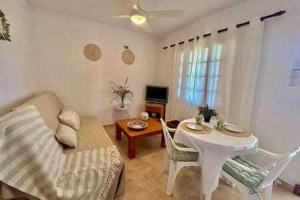 a living room with a couch and a table at SON BOU Apartamento en planta baja junto la playa in Son Bou