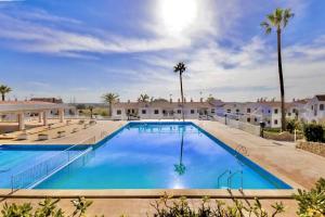 a large swimming pool with blue water at SON BOU Apartamento en planta baja junto la playa in Son Bou