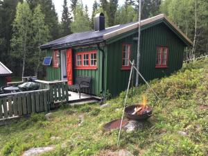 una cabina verde con un braciere di fronte di Øyungen 2 a Namsos