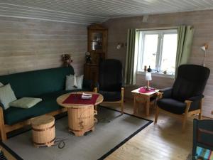 un soggiorno con un divano verde e 2 sedie di Øyungen 2 a Namsos