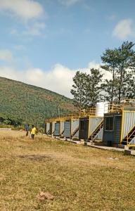 Des gens qui marchent dans un champ à côté d'une rangée de maisons dans l'établissement Rr resort, à Araku