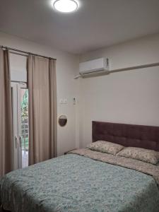 Ruby's Apartments Platamonas في بلاتامون: غرفة نوم بها سرير ونافذة