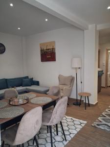 Ruby's Apartments Platamonas في بلاتامون: غرفة معيشة مع أريكة وطاولة وكراسي