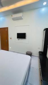 een slaapkamer met een bed en een tv aan de muur bij Rudrangan Suites Full Luxurious Villa Near Mahakaleshwar temple By AP villas and Resorts in Ujjain