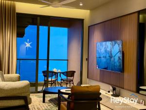 a living room with a tv on a wall at Antara Genting by HeyStay Management in Genting Highlands