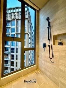a shower in a bathroom with a window at Antara Genting by HeyStay Management in Genting Highlands
