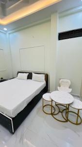 een slaapkamer met een bed en 2 tafels bij Rudrangan Suites Full Luxurious Villa Near Mahakaleshwar temple By AP villas and Resorts in Ujjain