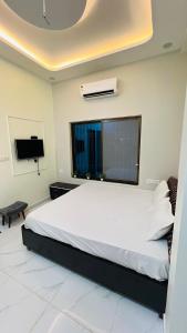 een slaapkamer met een groot bed en een tv bij Rudrangan Suites Full Luxurious Villa Near Mahakaleshwar temple By AP villas and Resorts in Ujjain +14 foto's