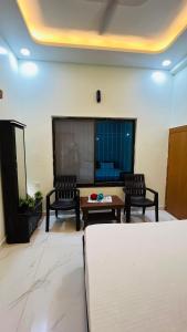 een woonkamer met twee stoelen en een tafel bij Rudrangan Suites Full Luxurious Villa Near Mahakaleshwar temple By AP villas and Resorts in Ujjain