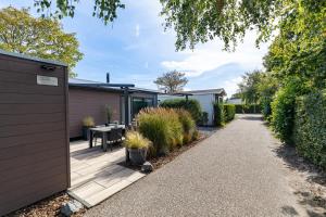 un giardino con un sentiero in legno che conduce a una casa di Beachhouse Renesse 2645 a Renesse