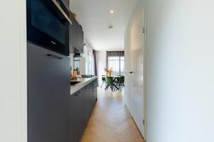 una cucina con armadi grigi e una sala da pranzo di Beachhouse Renesse 2645 a Renesse