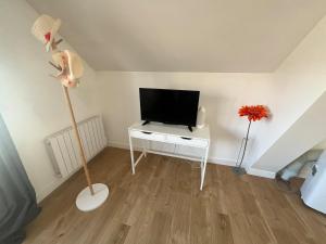 a living room with a tv and a desk with a television at Magnifique logement indépendant avec sa place de parking in La Celle-sous-Gouzon
