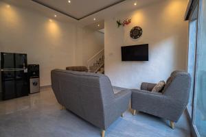 a living room with two couches and a tv at Villa cassia in Kerobokan