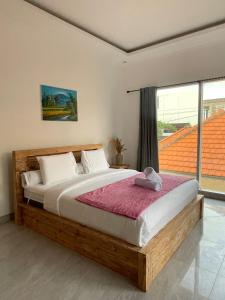 a bedroom with a large wooden bed with a window at Villa cassia in Kerobokan
