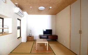 a living room with a table and a tv at Mcity in Wakasa in Naha