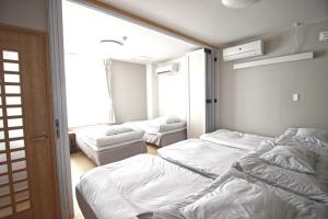 a room with three beds and a window at Mcity in Wakasa in Naha