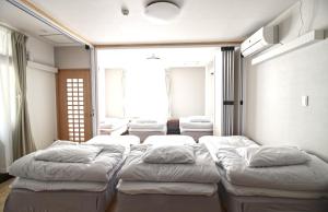 a bedroom with four beds in a room with windows at Mcity in Wakasa in Naha