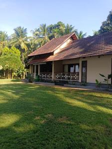 a house with a large lawn in front of it at BharathaPuzha Resort in Kārakkād