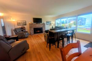 een woonkamer met een tafel en een open haard bij Surf and Sand Dollars in Seaside