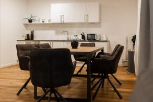 a kitchen with a dining room table and chairs at Modern-Apartment am Schloss - Claycation in Marktbreit