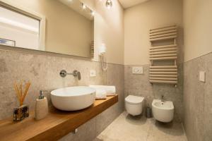 a bathroom with a sink and a toilet and a mirror at Riviera Suites - by Be Your Home in Civitavecchia