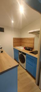 a kitchen with blue cabinets and a stove top oven at Le Derroja - Perpignan in Perpignan