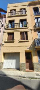 a tall building with windows and doors on a street at Le Derroja - Perpignan in Perpignan