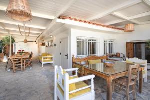 a dining room and living room with a table and chairs at Villa Arancia Private Pool, 2 Jacuzzis & BBQ Area in Pigi