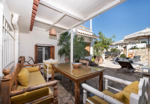 a patio with a wooden table and chairs at Villa Arancia Private Pool, 2 Jacuzzis & BBQ Area in Pigi +109 photos