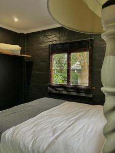 En eller flere senge i et værelse på Kloof Blackwood Cottage Modern Studio