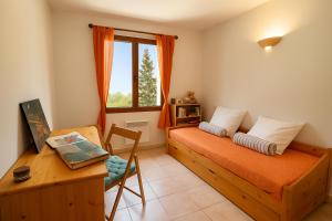 Un dormitorio con una cama y un escritorio y una ventana. en Villa la Baume, en Quinson