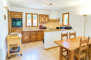 Una cocina con gabinetes de madera y una mesa de madera. en Villa la Baume, en Quinson