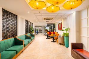 a waiting room with green couches and tables at The Embassy Hotel Hanoi in Hanoi