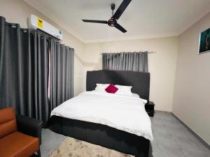 a bedroom with a bed with a ceiling fan at Aratina Apartments in Sunyani