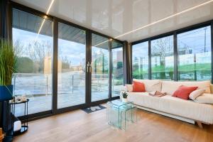 a living room with a white couch and large windows at Boat'n Flandres - Houseboat rooftop proche Lille in Deûlemont +48 photos