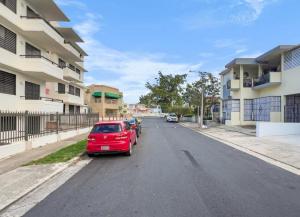 a red car parked on the side of a street at Hyde Park 6 Couples Retreat Apt With Jacuzzi in San Juan