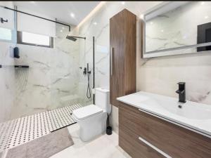 a bathroom with a toilet and a sink and a shower at Hyde Park 6 Couples Retreat Apt With Jacuzzi in San Juan +21 photos