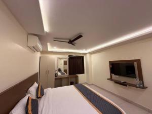 a bedroom with a bed and a flat screen tv at DVR GRAND-AC Rooms in Visakhapatnam