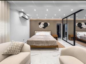 a bedroom with a bed and two chairs at Hyde Park 6 Couples Retreat Apt With Jacuzzi in San Juan