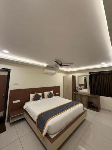 ein Schlafzimmer mit einem großen Bett und einem Deckenventilator in der Unterkunft DVR GRAND-AC Rooms in Visakhapatnam