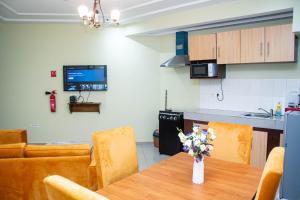 a kitchen and a dining room with a table and chairs at Résidence Romacy, appartement 2 chambres avec balcon à Ahala, quartier résidentiel de Yaoundé in Yaoundé