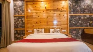 The Forest Resort By 3Tree Group في رامناجار: سرير في غرفة ذات جدار خشبي +31 صورة