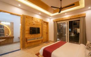 The Forest Resort By 3Tree Group في رامناجار: غرفة نوم مع سرير وتلفزيون بشاشة مسطحة