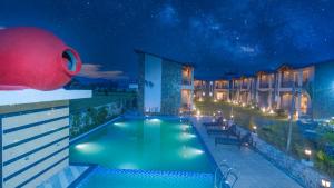 The Forest Resort By 3Tree Group في رامناجار: حمام سباحة على جانب الفندق في الليل