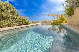 een zwembad met blauw water en een parasol bij Appartamento Marinaia Panorama in Marittima