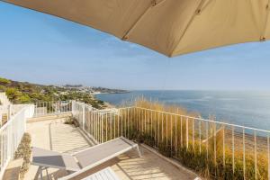 een balkon met een stoel en een parasol bij Appartamento Marinaia Panorama in Marittima