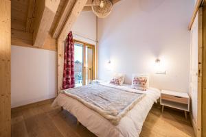 een slaapkamer met een bed en een groot raam bij Chalet Salt Lake in La Toussuire